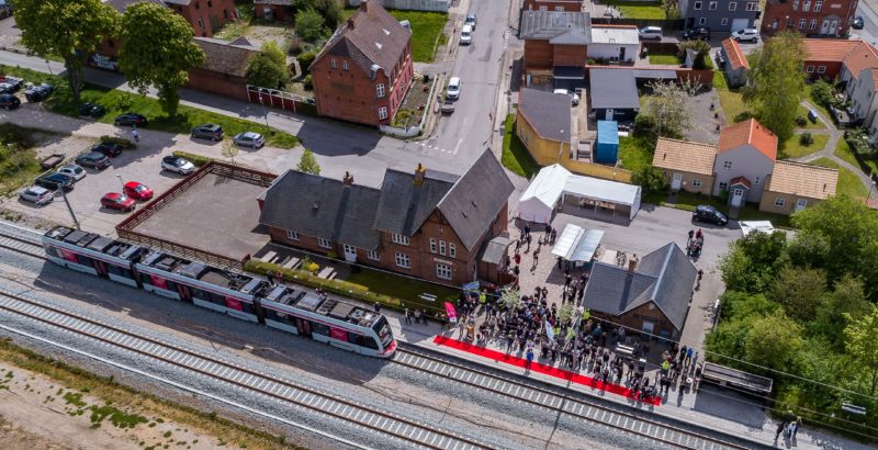 Trustrup Station med holdende letbanetog og menneskemylder Trustrup Station med holdende letbanetog og menneskemylder